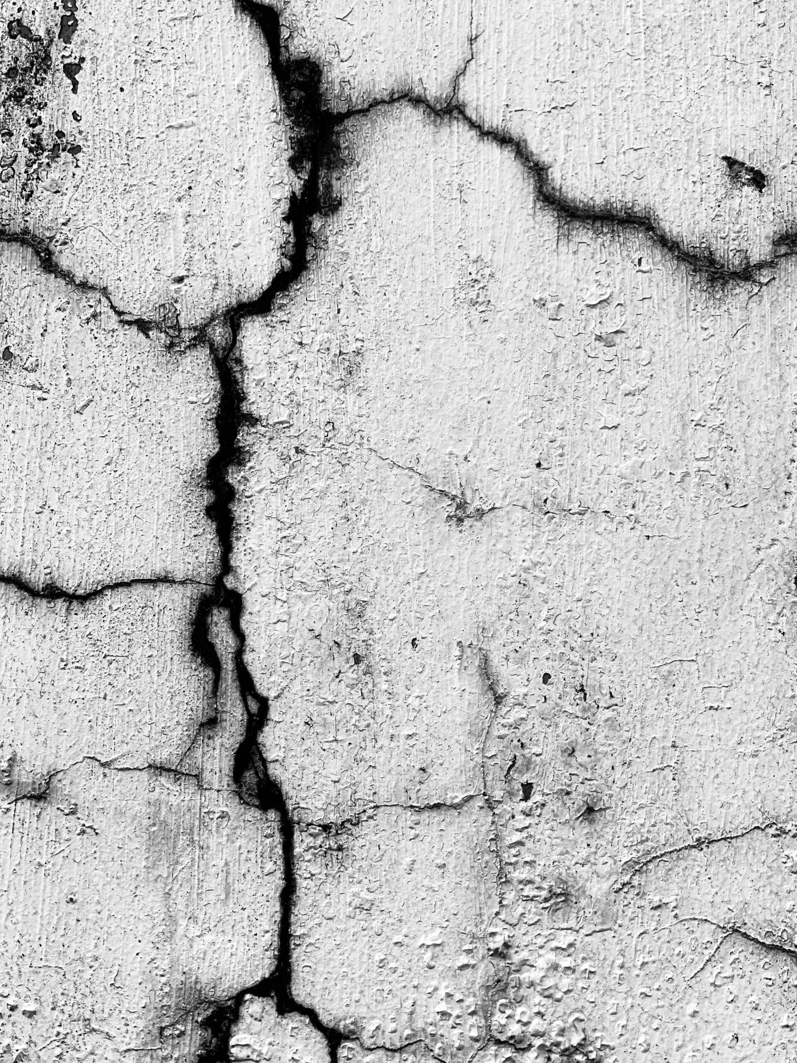 Weathered concrete wall with spalling before repair