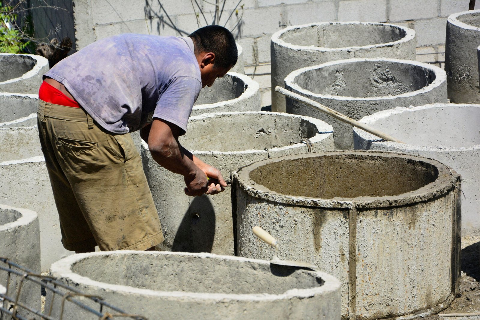 Technician repairing a damaged concrete structure outdoors